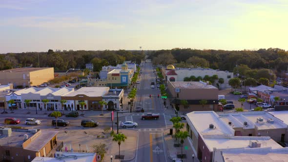 Forward Pan of Shops and Restaurants on the Main Road of a Small Town at Sunset alt