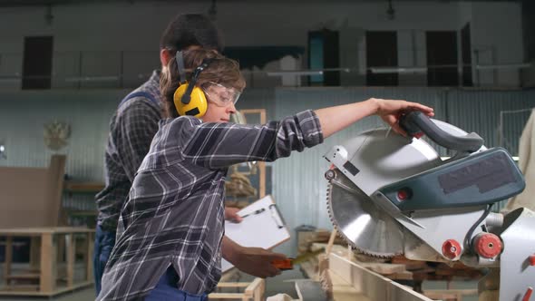 Workers Using Circular Saw in Carpentry Shop alt