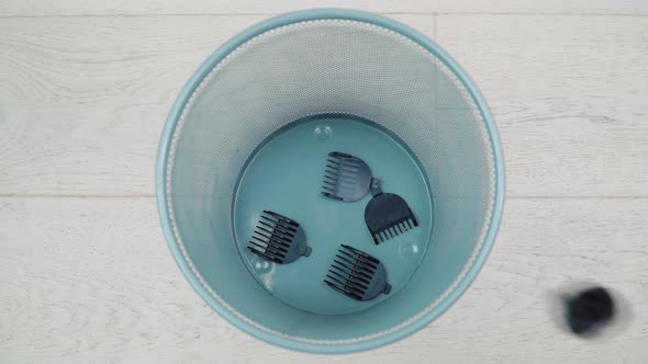 An Old Hair Clipper with Nozzles Falls Into the Trash alt