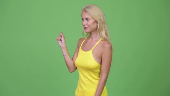 Young Happy Beautiful Blonde Woman Snapping Fingers and Showing Something