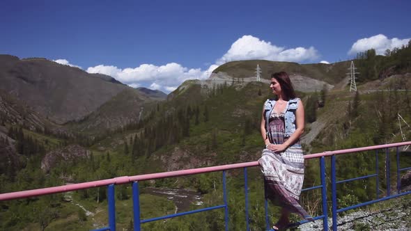 A Beautiful Girl is Sitting at a Height and Admiring the Beautiful Nature alt