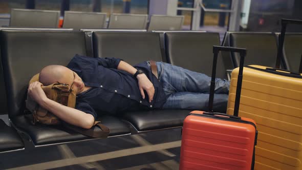 Young Man Sleeping While Waiting the Plane at Airport Passenger Terminal