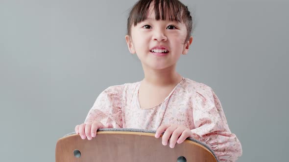 Child playing on the chair at home and looking at camera. Kids happy concept. alt