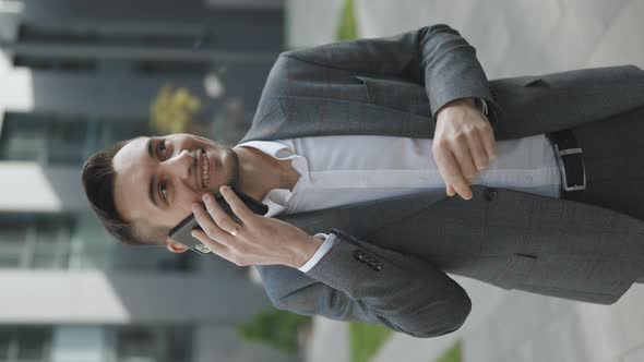 Video Footage With European Businessman Talking on Mobile Phone Near Office Building alt
