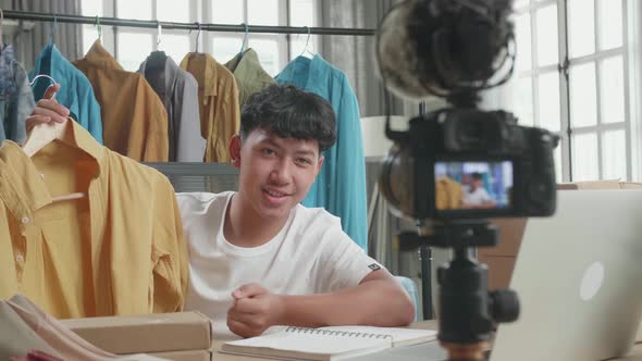Asian Man Online Seller Recommending A Shirt And Recording Video By Camera While Using Computer alt