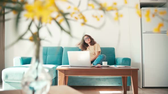 A Young Woman Remote Employee Working From Home with a Laptop