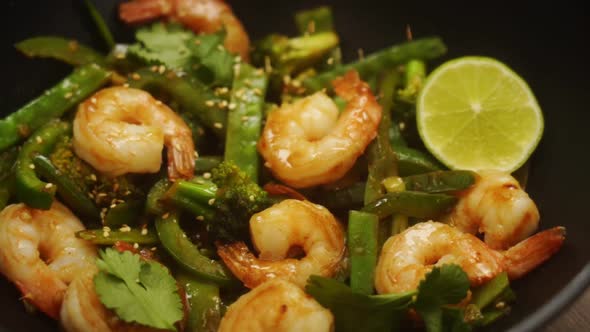 Unrecognizable person serving appetizing dish with shrimps with sesame seeds alt