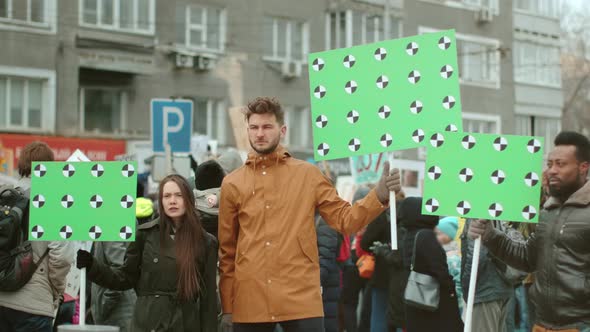 White and Dark Skinned Protest Activists at City Riot with Greenscreen Banners