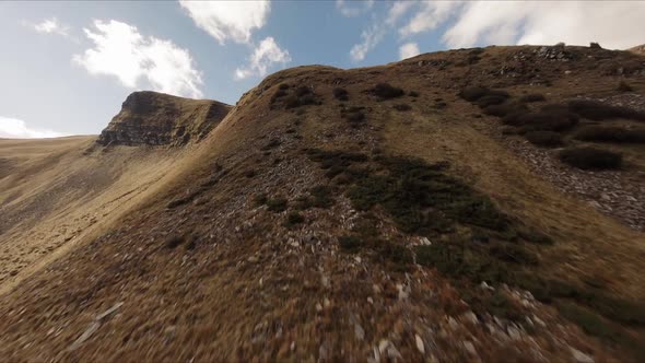 FPV Drone Footage Smooth Stabilized Fly Along Mountain Rocky Hill Around Highland Lake alt