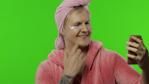 Portrait of Transsexual Man in Bathrobe Using Mobile Phone for Video Call alt