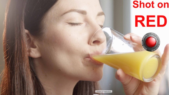 Thirsty Woman Drinking Orange Juice Indoors With Sun Shining A Close Up Shot On Red Camera alt