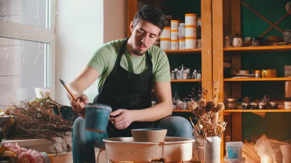 Pottery - the Master Is Putting Down a Bucket of Paint and Wiping Sweat From His Forehead alt