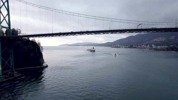 Lions Gate or First Narrows Bridge and cargo ship in background, Vancouver in Canada. Aerial backwar alt
