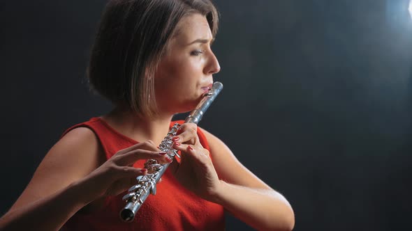 Professional Musician Female Playing on Flute. Smoky Studio