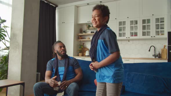 Excited Black Boy and Dad Celebrating Touchdown While Watching Super Bowl Game alt