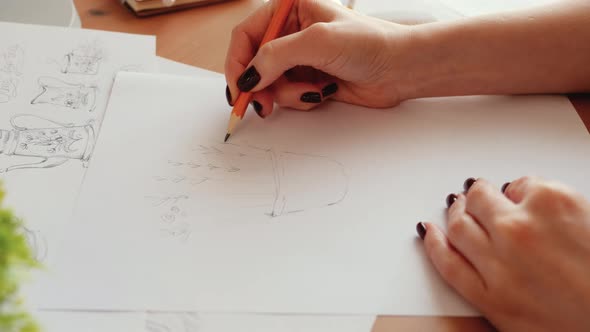 Woman Designer sketching on white paper, working from home office