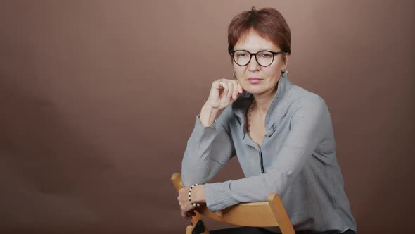 Studio Portrait of Mature Woman Sitting on Chair alt