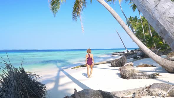 Slow motion: adult mature woman walking on tropical beach turquoise water caribbean sea alt