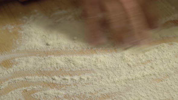 Male Hands Kneading Dough in Flour on the Table