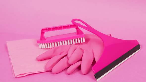 A Rag Rubber Latex Gloves a Pink Plastic Brush and a Window Cleaner