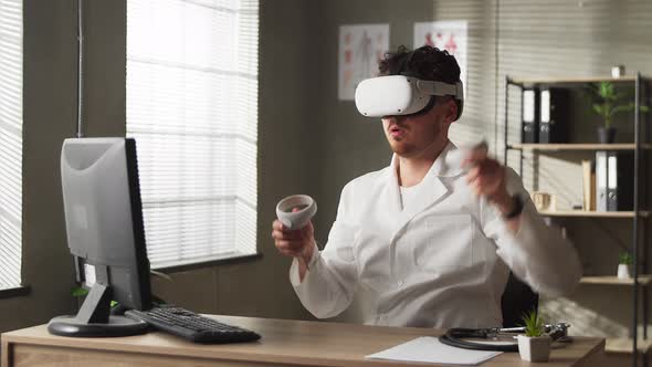 Caucasian Male Neurosurgeon Wearing Virtual Reality Headset Uses Controllers to Remotely Operate alt