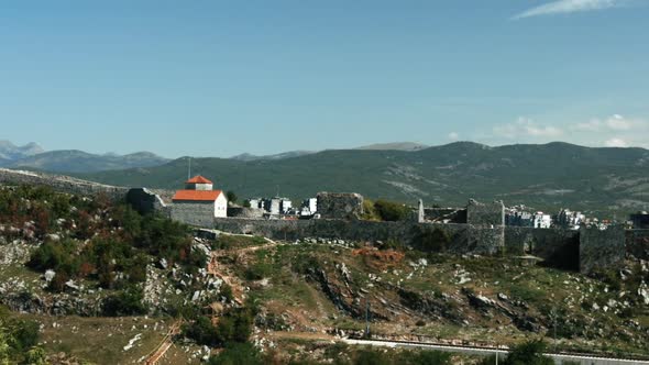 High mountain ranges next to old buildings alt
