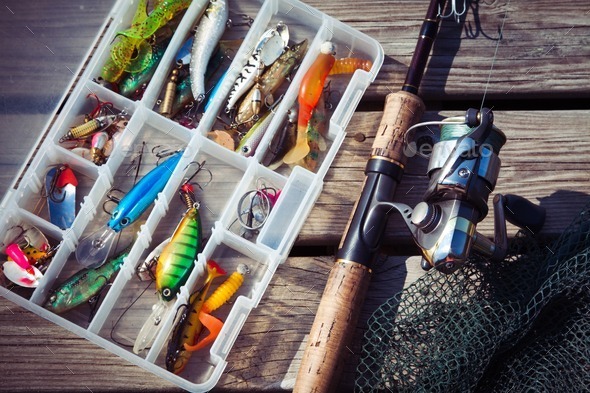 Fishing Lures in tackle boxes with spinning rod and net Stock Photo by  nblxer