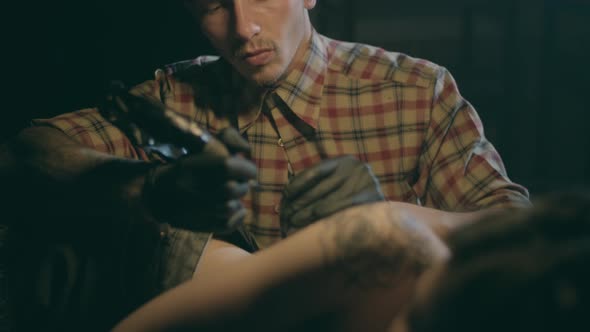 Shot of Tattoo Artist in Creation. The Professional Master Does the Tattoo for Hipster Woman or Girl alt