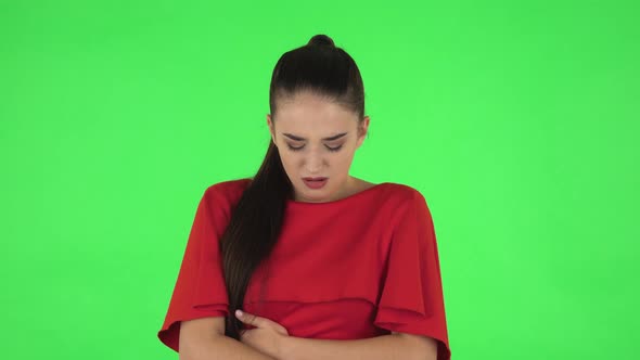 Portrait of Pretty Young Woman Is Feeling Very Bad, Her Stomach Hurting, Feeling Nausea. Green alt