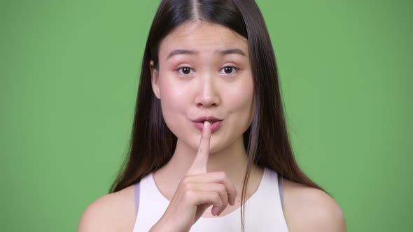 Young Beautiful Asian Businesswoman with Finger on Lips