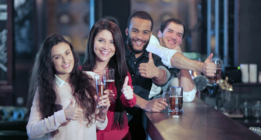 Company of guys and girl celebrating at the bar