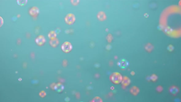 Beautiful Colorful Soap Bubbles Illuminated By Pink Light Fly Indoors on a Blue Background alt