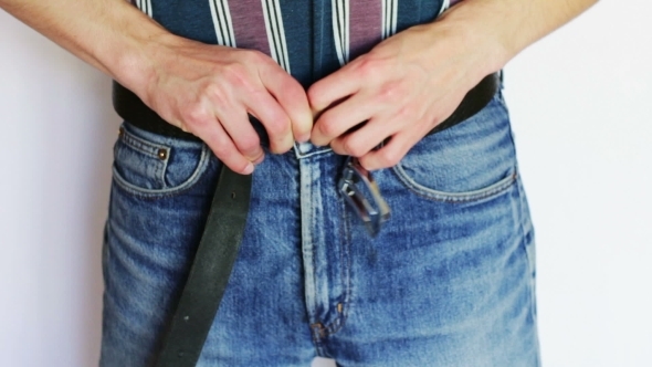 The Man Fastens His Pants To Jeans. alt