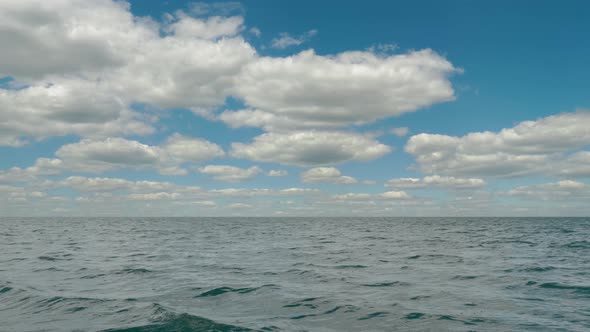 Accelerated, time-lapse movement of clouds over the waves of the sea
