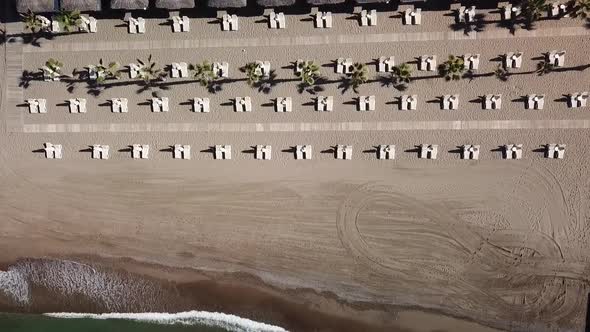 Top down descending view of beach beds in luxury resort alt