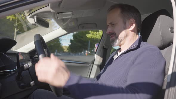 A Middleaged Handsome Caucasian Man Adjusts Things in His Car  Side Closeup