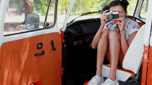 Woman clicking photo while sitting in camper van 4k alt