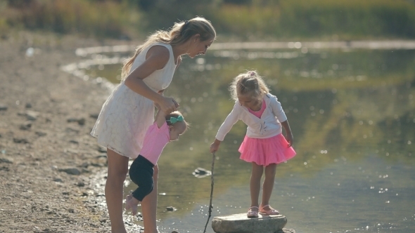 Mom Walks With Her Little Cute Girls Near Lake