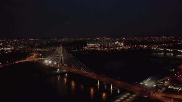 . Aerial Pan of Downtown Warsaw Skyscrapers and Bridge Dark Winter Night Light. alt