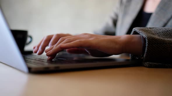 Closeup a woman working and typing on laptop computer keyboard on the table