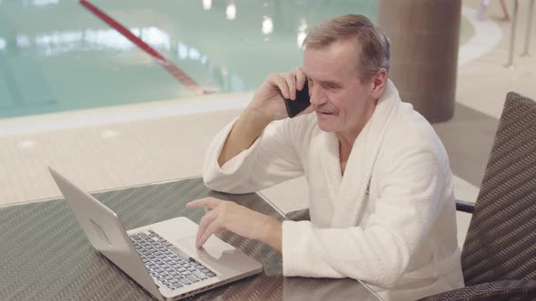 senior-businessman-using-devices-in-swimming-pool-stock-footage