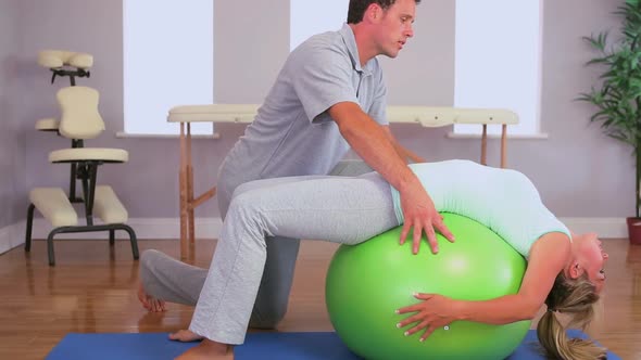 Physiotherapist Working With A Patient On An Exercise Ball alt