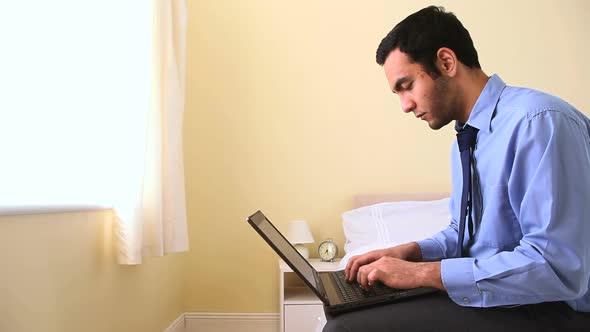 Portrait Of A Businessman Using His Laptop In Bed alt