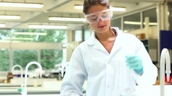 Pretty Science Student Pouring Chemical Through Funnel alt
