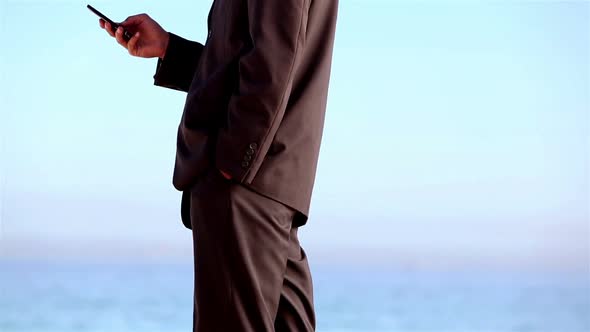 Unstressed Businessman Throwing His Phone On The Beach alt