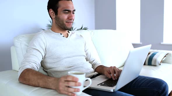 Man Drinking A Coffee While Using His Notebook 1 alt