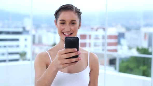 Young Woman Showing Her Mobile Phone And Texting A Message alt