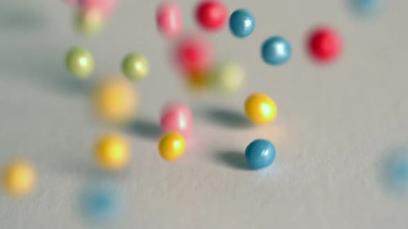 Sugar Balls Falling Onto Grey Surface alt