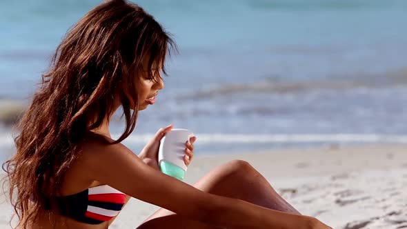 Woman Applying Sun Cream On The Beach alt