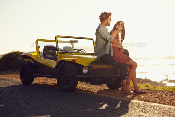 Romantic, Young Couple Sitting On The Bonnet Stock Photo, Picture